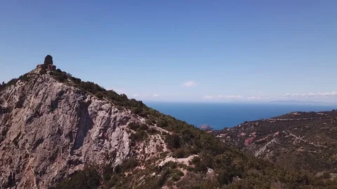 Aerial approach to a peak with Tower on a cliff by the sea, sunny summer day Stock Footage 107189170