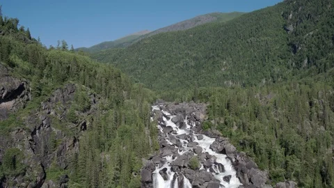 Aerial approach to a rocky waterfall View of the valley with a powerful river Stock Footage 123710906