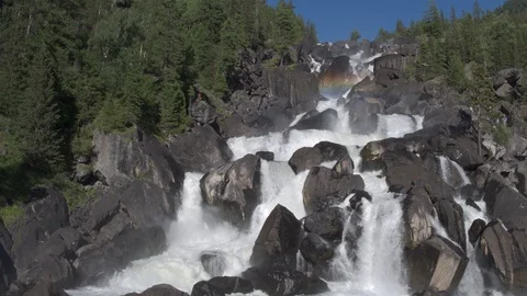 Aerial approach to a rocky waterfall View of the valley with a powerful river Stock Footage 123711443