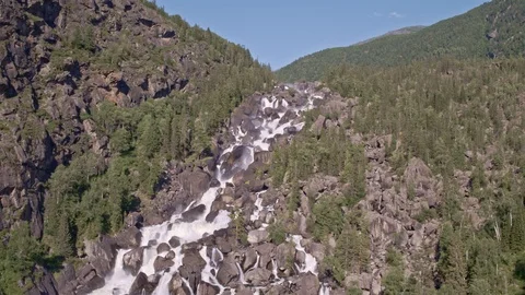 Aerial approach to a rocky waterfall View of the valley with a powerful river Stock Footage 123714311