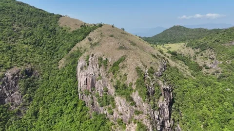 Aerial approach to rugged cliff with sparse trees, Nha Trang Vídeo Stock 340880054