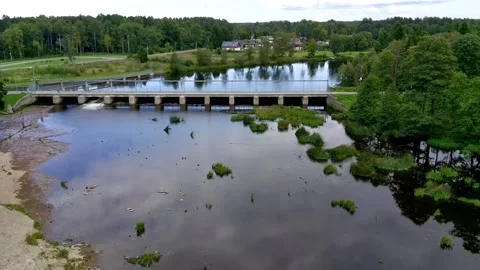 Aerial approach shot towards a small rural concrete river dam bridge Stock Footage 344759873