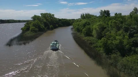 Aerial approaching to boat navigating narrow steam during sunny day Stock Footage 152097053