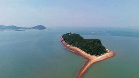 Aerial approaching forested Nue Island with sandy spit and turquoise sea in Stock Footage 336629853