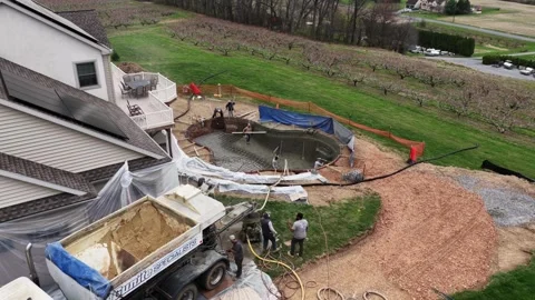 Aerial approaching shot construction crew installing backyard swimming pool Stock Footage 333397397