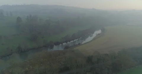 Aerial approaching two rowing crews on river in English countryside on misty Stock Footage 108042368