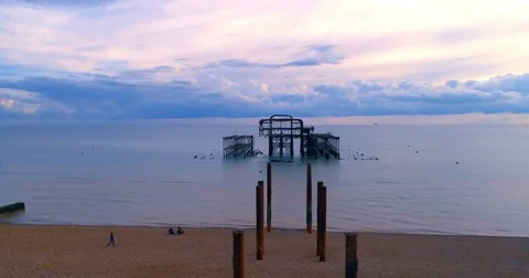 Aerial approaching view of the destroyed West Pier in Brighton at sunset Stock Footage 80987316