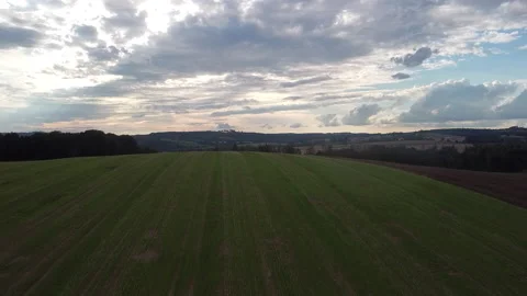 Aerial ascend over fields towards cloudy sunset Stock Footage 161108485