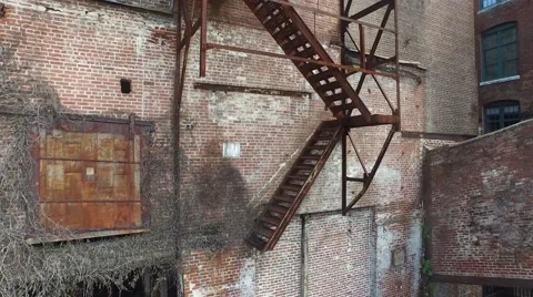 Aerial ascend up a rusty fire escape on abandoned factory Stock Footage 50649482