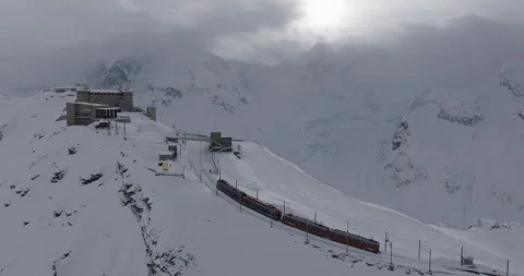 Aerial Ascending Backward Shot Of Train Moving Towards Observatory On Snow - Stock Footage 309330070