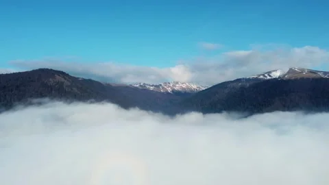 Aerial ascending view above clouds with mountains in the background Stock Footage 234640810