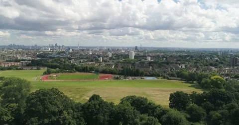 Aerial ascending view over a park revealing the skyline of central London Stock Footage 78613287