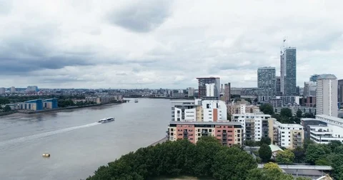 Aerial ascending view of the river Thames by the docklands in London Stock Footage 77750872