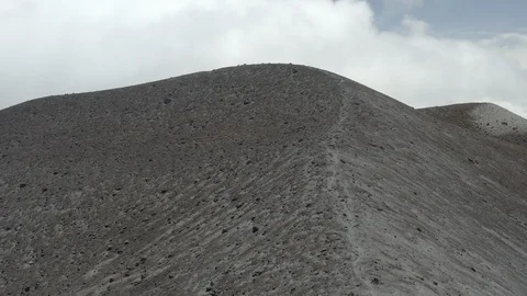 Aerial ascends hill to reveal string of volcanos on a ridge behind Purace Vídeos de archivo 104991141