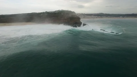 Aerial of atlantic ocean splashing against rocky surfaces of cliff foaming up Stock Footage 157703553