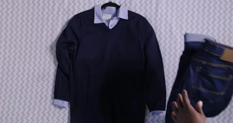 Aerial of autumn fall clothes jeans shirt scarf belt boots thrown on the bed Stock Footage 204046888