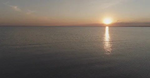 Aerial back fly over teen girl walking on baltic sea beach barefoot in sunset Stock Footage