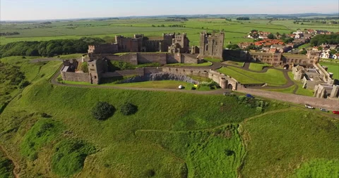 Aerial Back: Imposing Stone Castle Perches High Above Beach and Patchwork Fields Stock-Footage 149182818