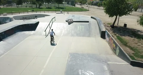 AERIAL BACK SHOT OF BIKER DOING TRICKS IN SKATE PARK Stock Footage 102379181