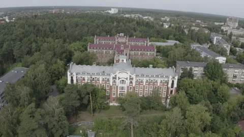 Aerial backward ascent over old buildings and forest Video stock 333012183