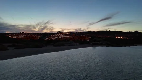 Aerial Backward Drone Flight Over Sardinian Coastline Hotel at Sunset Vídeo Stock 334564435
