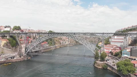 Aerial: Backward drone flight over Dom Luis I Bridge with boats and people on Video stock 345108401