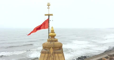 Aerial backward drone  view of trisula in the top of the mandir in Somnath Stock Footage 195305750