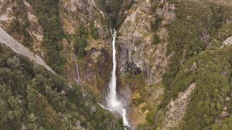 Aerial backward flight over Devils Punchbowl Waterfall in Arthurs Pass, New Stock Footage 333016365