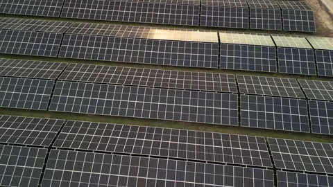 Aerial backward flight over solar panel farm reflecting sunset light. Stock-Footage 335652103
