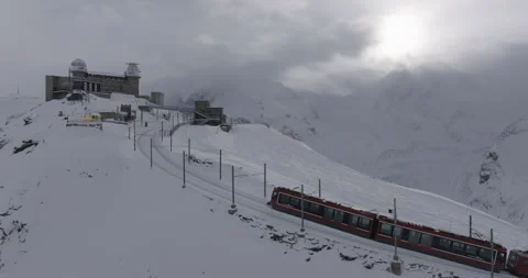 Aerial Backward Panning Shot Of Train Moving Towards Observatory With Snow - Stock Footage 309330305