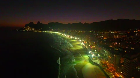 Aerial Backward Shot Of Illuminated Ipanema Beach In City Against Sky At Night - Stock Footage 254118657