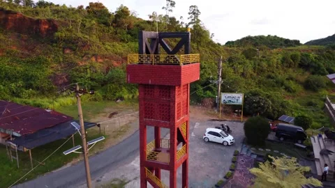 Aerial Backward View of a Coastal Tower with Green Hills Background Stock Footage 342278834