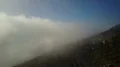 Aerial backwards flight over foggy sunny mountain road at clouds altitude 4k 4k or 4k+ Resolution