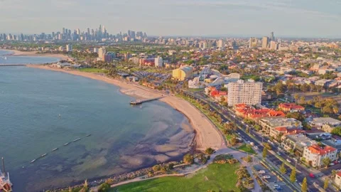 Aerial backwards flight over St Kilda Beach with Melbourne CBD skyline 스톡 동영상 321783219