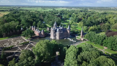 Aerial backwards movement showing Haar Castle surrounded by a moat and a lush Stock Footage 338016512