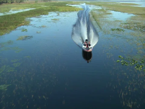 Aerial of bass boat passing under camera Stock Footage