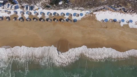 Aerial Beach Coastline With Rolling Waves And Organized Sun Umbrellas Stock Footage 328283055
