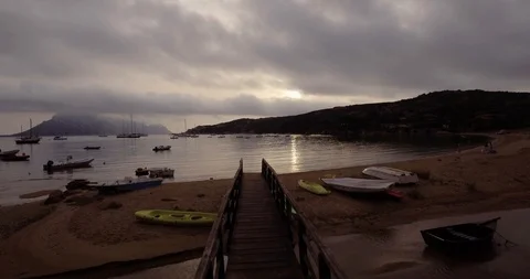 Aerial, beautiful empty beach in a bay in Sardinia island on a cloudy and dar Vidéo 100151397