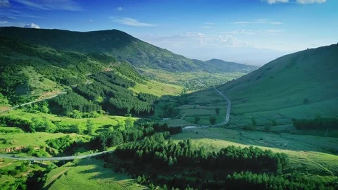 Aerial beautiful landscape mountain green tree forest road blue sky sunny nature Stock Footage