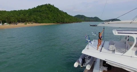 Aerial: Beautiful model posing on the yaht near the beach. Phuket. Thailand. Stock Footage 76692246