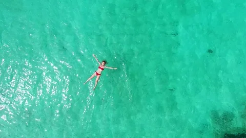 AERIAL : Beautiful young woman swimming Stock Footage