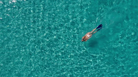 Aerial - Beautiful young woman in white bikini snorkeling in crystal clear water Stock Footage