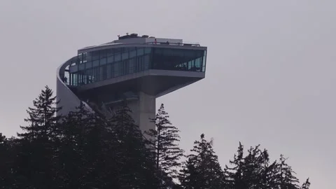 Aerial Bergisel Ski Jump Tower above fir trees in Innsbruck, Austria Vídeos de archivo 331022046