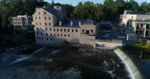 Aerial Beside Elora Mill Stone Hotel And Spa By Dam Flowing On The River Stock Footage 200769853