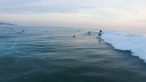 Aerial of big group of professional surfers surfing alongside of big ocean wave 스톡 동영상 158056341