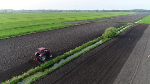 Aerial bird eye view of tractor plowing dark brown soil 4k Stock Footage 75346501