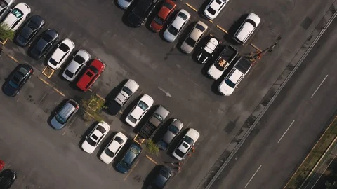 Aerial bird's eye view of rows of cars in a parking lot with a solar panel Stock Footage 127988944