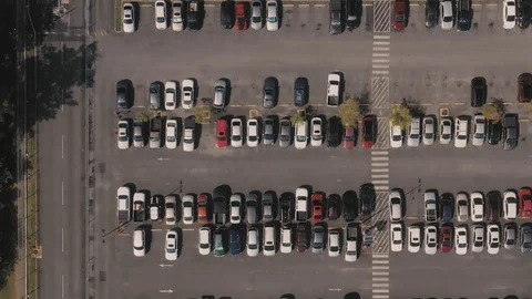 Aerial bird's eye view of rows of cars in a parking lot with a solar panel Stock Footage 127989147