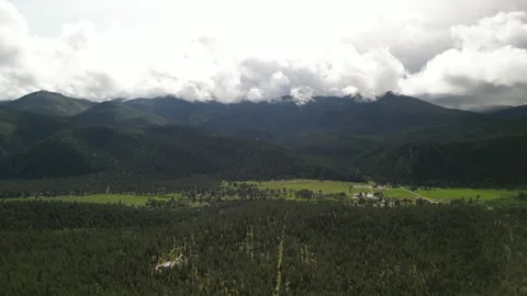 Aerial of Bitterroot Mountains and meadows in Montana in spring with low clouds Stock Footage 311826141