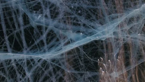 Aerial blue cracked ice patterns on frozen lake Snowstorm arctic polar climate   Video stock 317963621